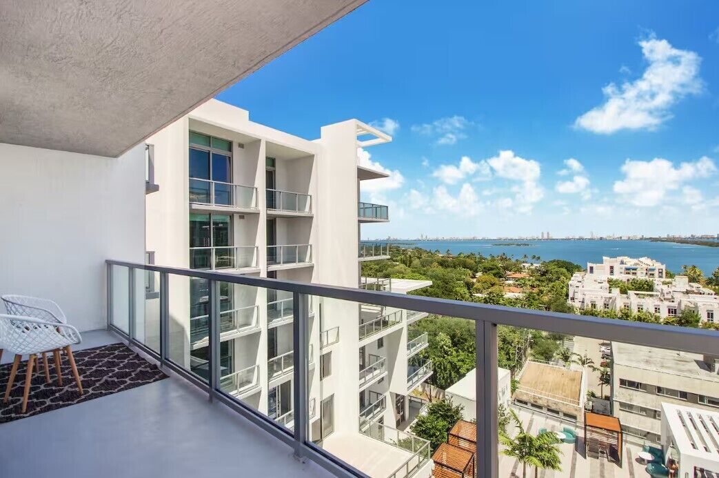Un bâtiment moderne doté de nombreux balcons, de grandes fenêtres et offrant une vue sur la mer.