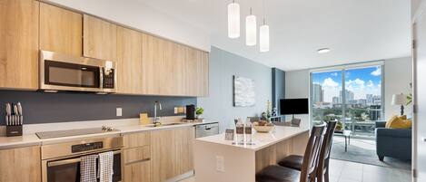 Een moderne keuken met houten kastjes, roestvrijstalen apparatuur en een groot eiland met barkrukken.