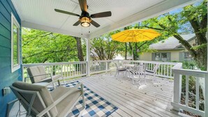 A covered porch with a ceiling fan, outdoor furniture, and a yellow umbrella. - Serene 3BR home in Historic Downtown Norcross (Norcross)