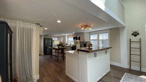 Una cocina amplia con una isla central, piso de madera y un tragaluz.