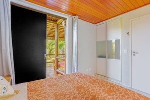 Una camera da letto con un letto, un armadio e una porta scorrevole che dà su uno spazio all'aperto.