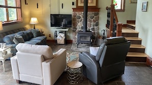 Una sala de estar acogedora con chimenea, asientos cómodos y televisor.