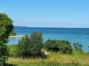 Un paisaje costero con una vista despejada del mar, abundante vegetación y una costa distante.
