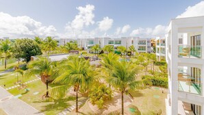 A resort with modern buildings, palm trees, and a pool area.