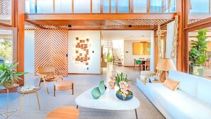 Ein großzügiger Wohnbereich mit hohen Decken, Holzbalken und modernem Interieur.