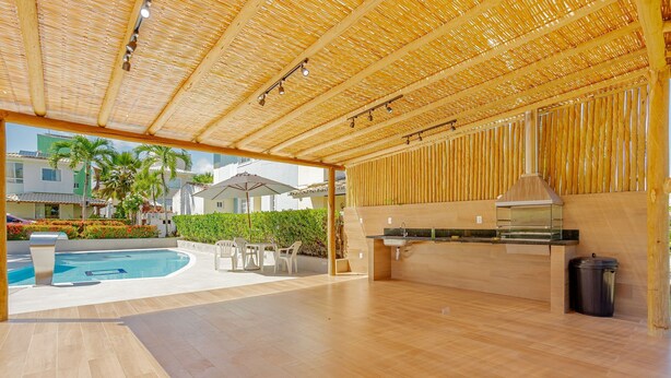 An outdoor kitchen area with a pool and patio furniture.