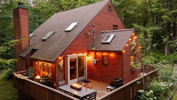 A red cabin with a deck, a fire pit, and a covered outdoor seating area. - Mt Snow Chalet: Peaceful Escape w/Hot Tub (Wilmington)