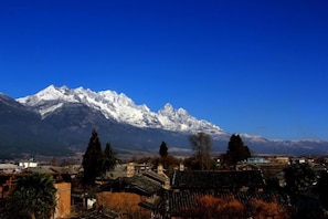 Un paisaje montañoso con picos nevados y un pueblo en primer plano.