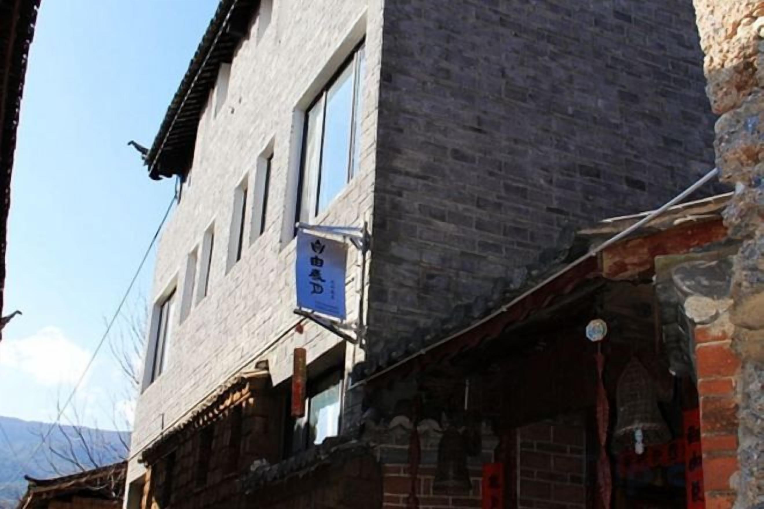 A traditional building with a brick facade, a visible bell tower, and a signboard.