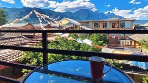 A traditional building with a view of mountains. - Ziyou Suiyue Design Hostel (Yulong)