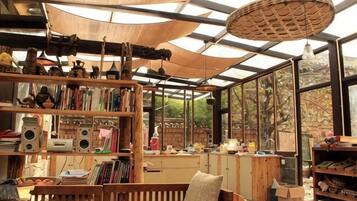 Une pièce dotée d’une grande fenêtre, d’une bibliothèque en bois et d’un luminaire suspendu.