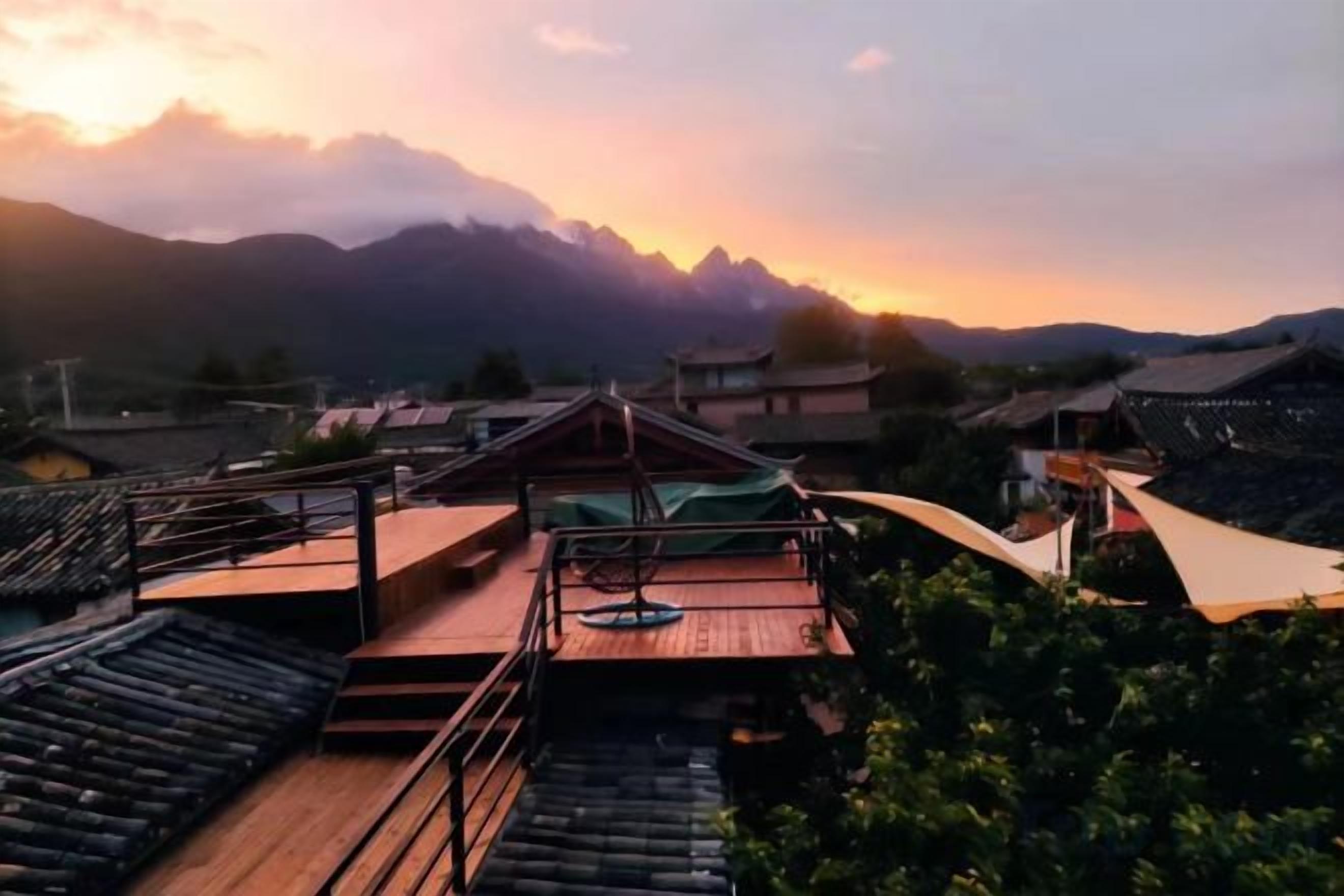 A traditional building with a wooden deck and a view of mountains.