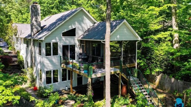 A two-story house with a balcony and a staircase leading to a deck. - Stepping Stone Cove :: Lakefront w/ Dock, Fireplaces & Hot Tub (Mineral)
