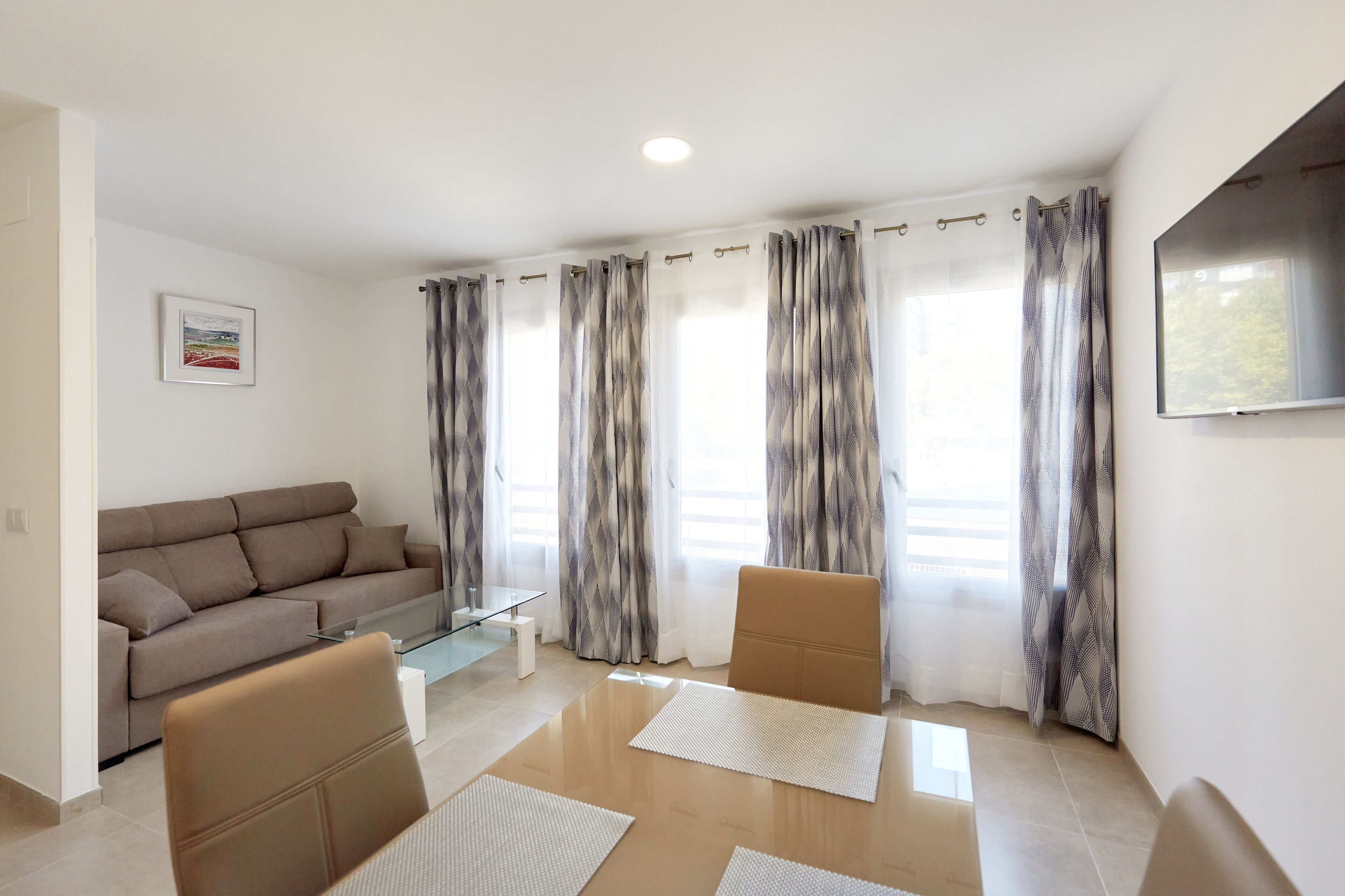 A modern living room with a sofa, a coffee table, and two chairs.