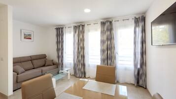 A modern living room with a sofa, a coffee table, and two chairs.