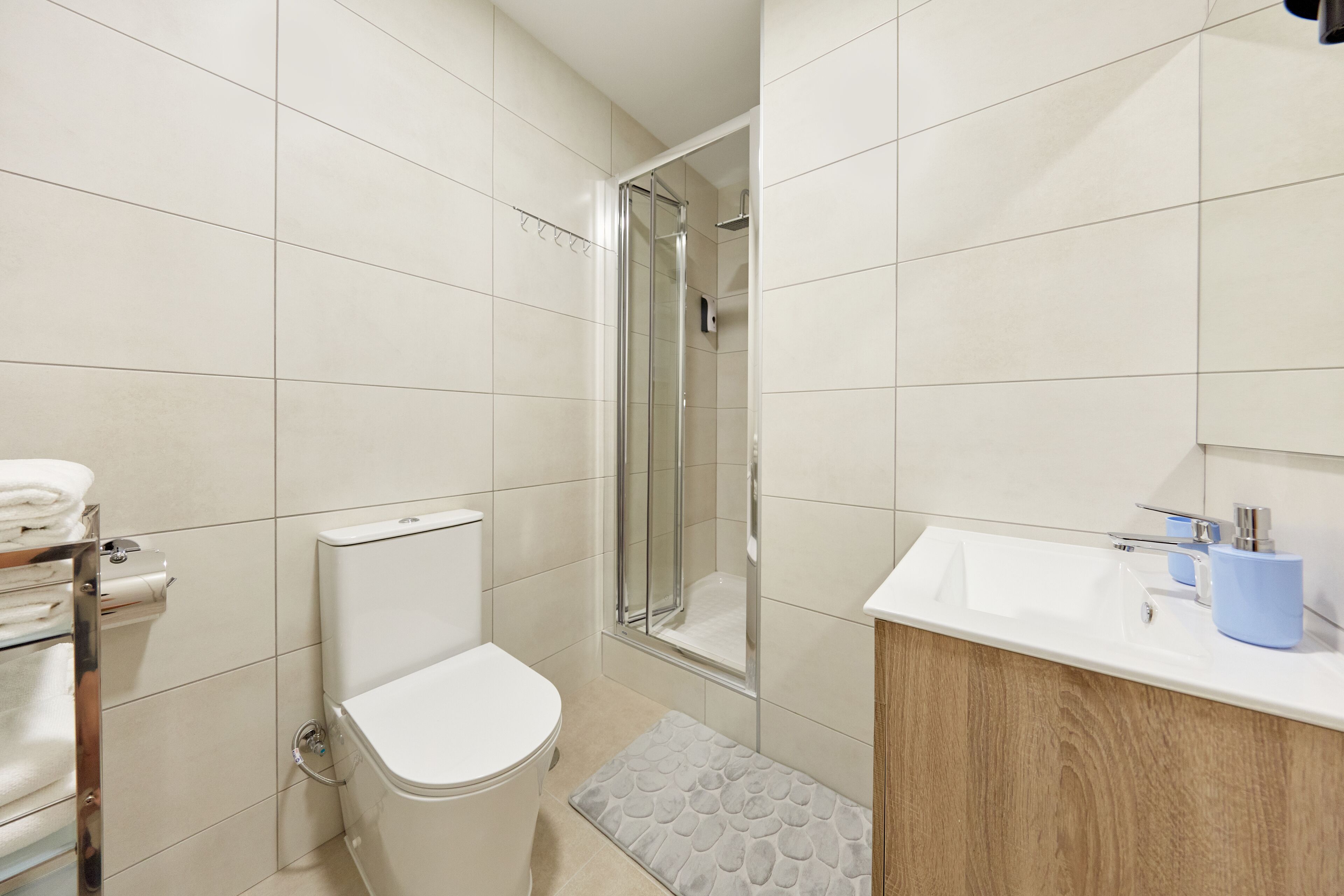A modern bathroom with a toilet, shower, and sink.