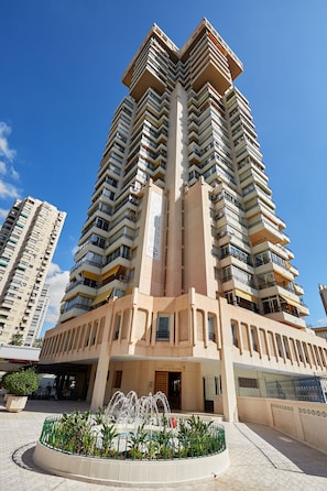 A high-rise building with multiple balconies and a central courtyard with a fountain. - Sonrisa Deluxe Apartments Levante (Benidorm)