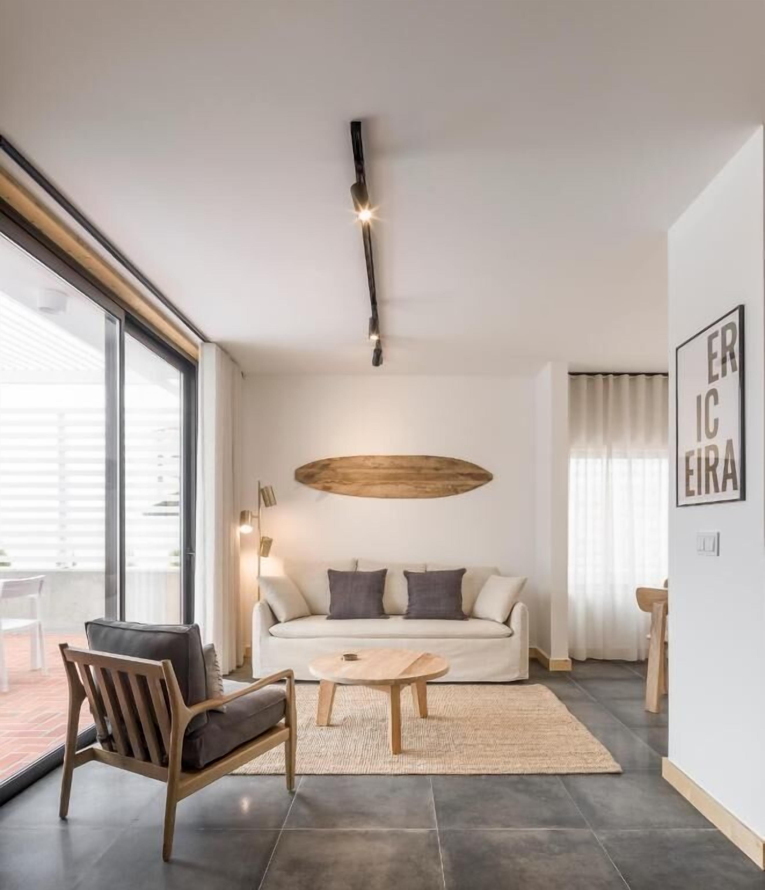 Un salon moderne avec un canapé, une table basse et des chaises en bois.