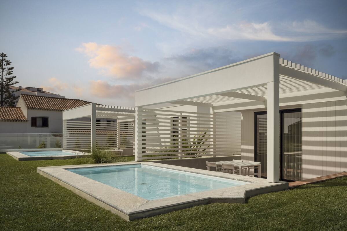 Un espace piscine extérieur moderne, doté d’un espace salon couvert et d’une piscine.