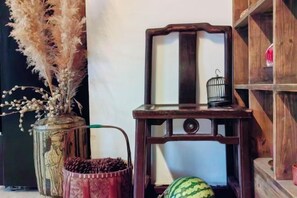 A wooden chair with a metal frame, a small metal birdcage, and a vase with dried plants. - Jingdezhen Guiran Inn (Jingdezhen)