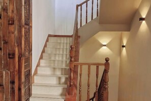 A wooden staircase with a handrail and a light fixture on the wall. - Jingdezhen Guiran Inn (Jingdezhen)