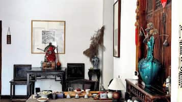 Una habitación tradicional con una mesa de comedor preparada, una estatua y un jarrón grande.