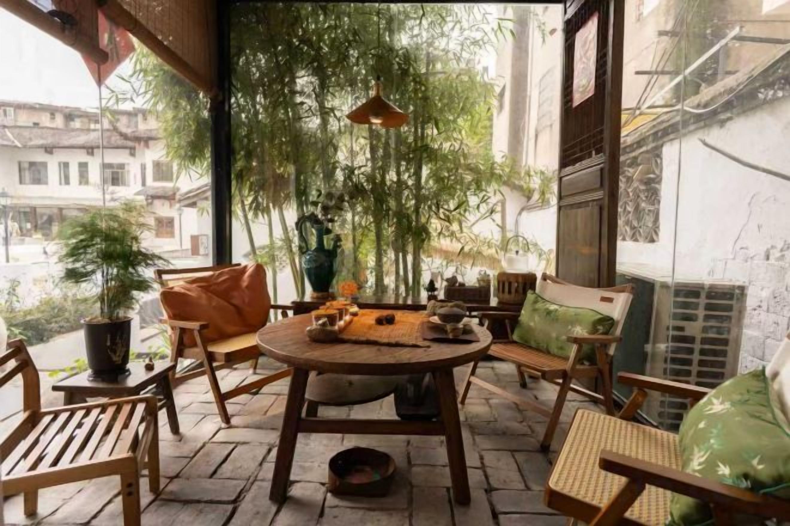 Un patio con mobiliario de madera, una mesa y plantas colgantes.
