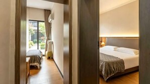 A hotel room with a bed, bedside table, and a view of the outdoors. - Jingdezhen Guiran Inn (Jingdezhen)