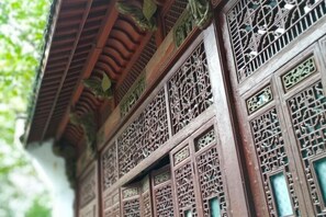 A traditional building with intricate wooden lattice windows and a tiled roof.
