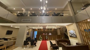 A hotel lobby with a red carpet, seating area, reception desk, and a large chandelier. - KARTAL PARK OTEL (Sirnak)