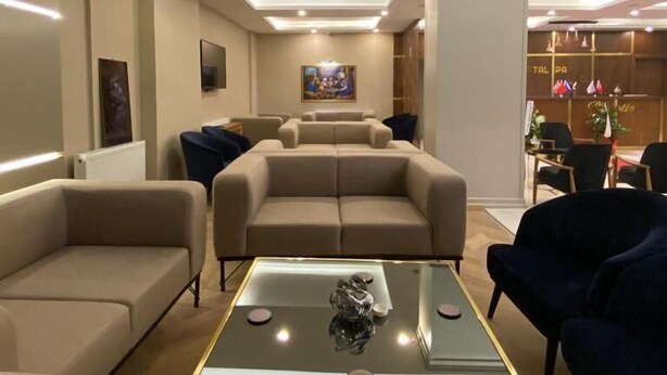 A modern living room with sofas, a glass coffee table, and recessed lighting. - KARTAL PARK OTEL (Sirnak)