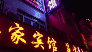 A building with illuminated signage in yellow and red neon lights. - Yingjia Hotel (Zhongshan)