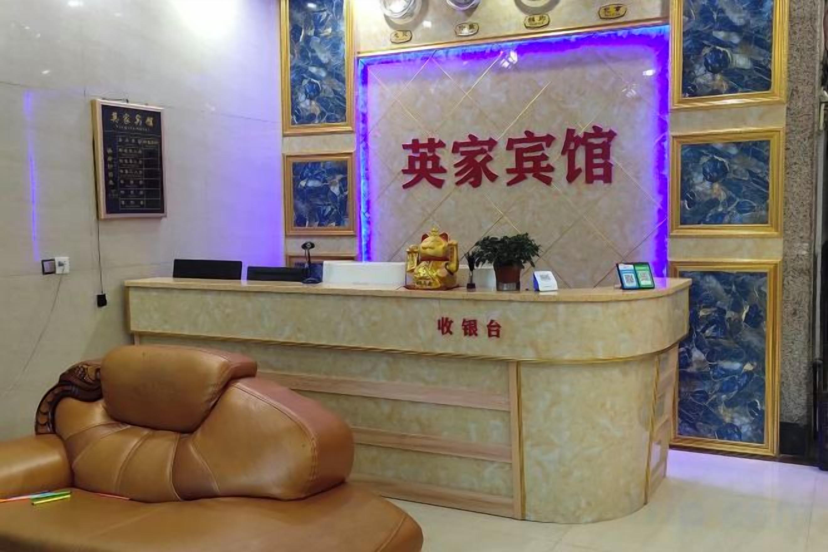 A reception desk with a marble counter, a leather chair, and a decorative wall with a sign above it.