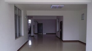 A spacious, empty hallway with a polished floor and white walls. - Yingjia Hotel (Zhongshan)