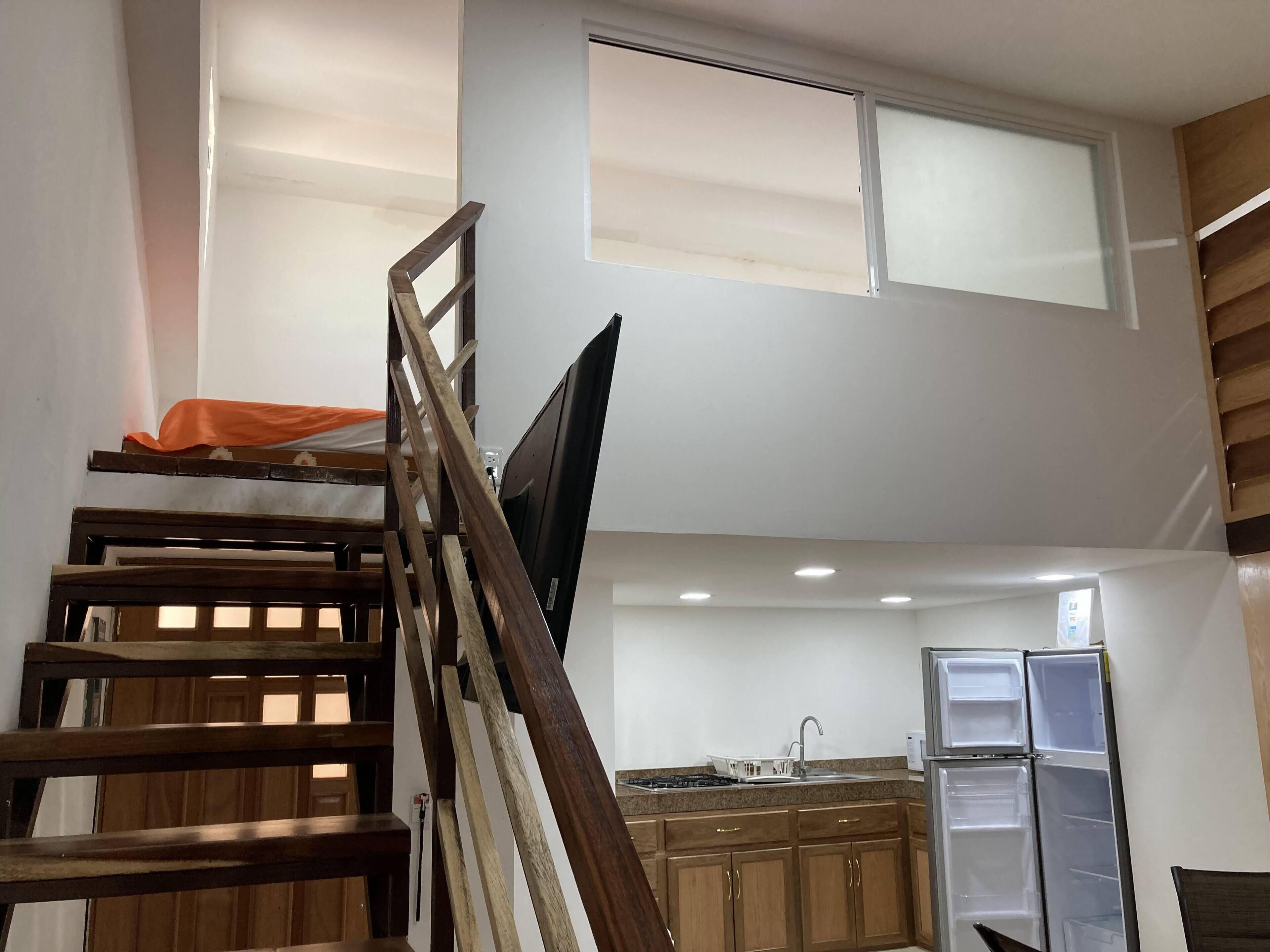 Una cucina compatta con mobili in legno e un frigorifero integrato.