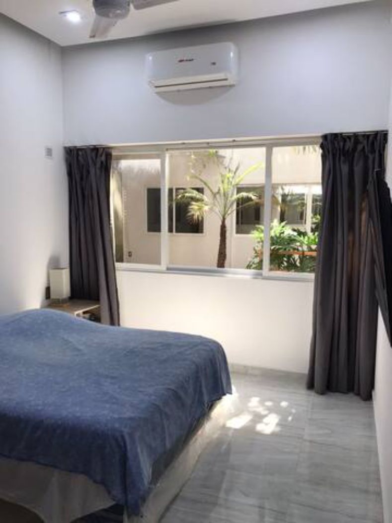 Un dormitorio con cama, ventana y equipo de aire acondicionado.