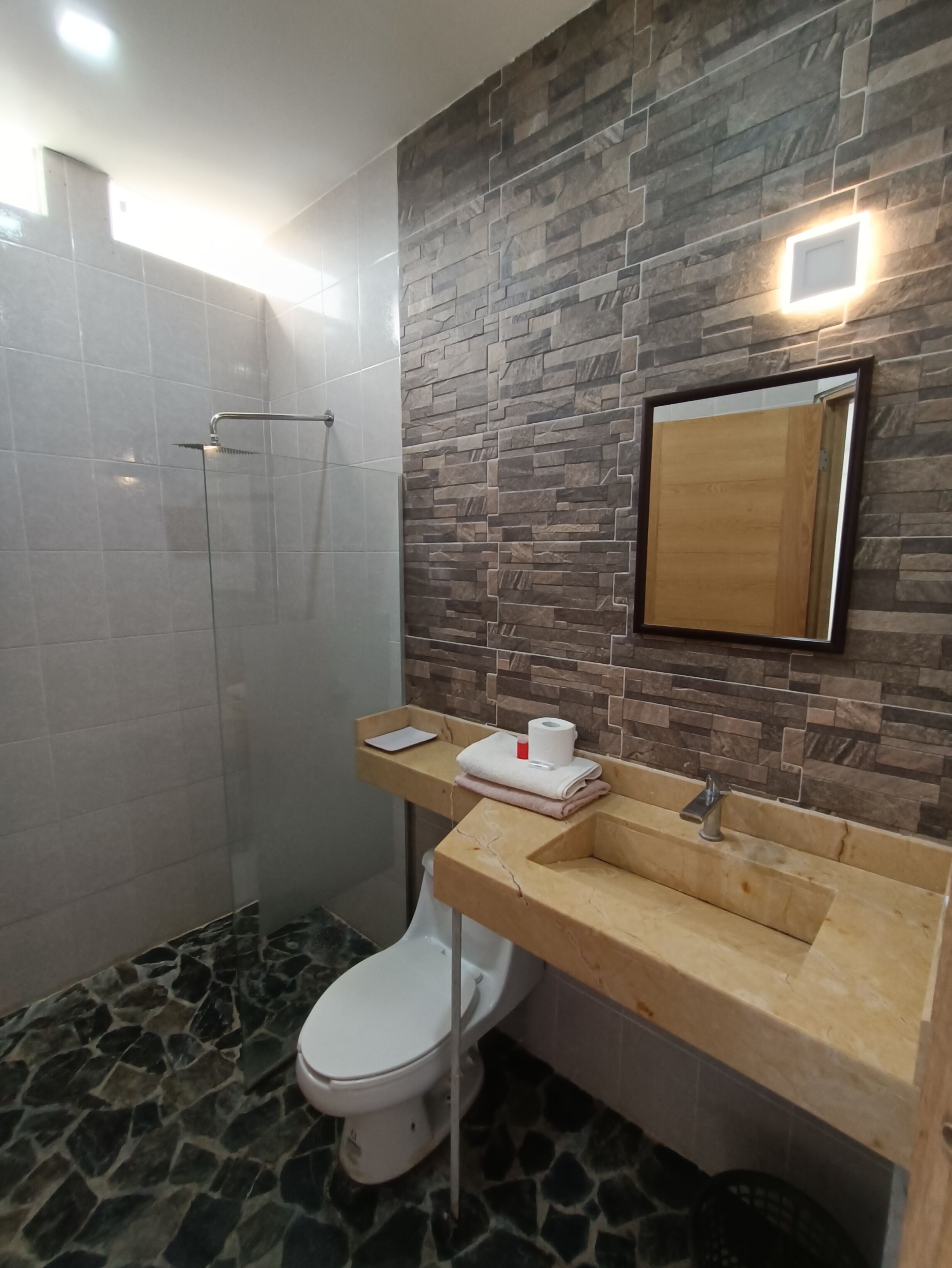 A bathroom with a shower, toilet, and sink.