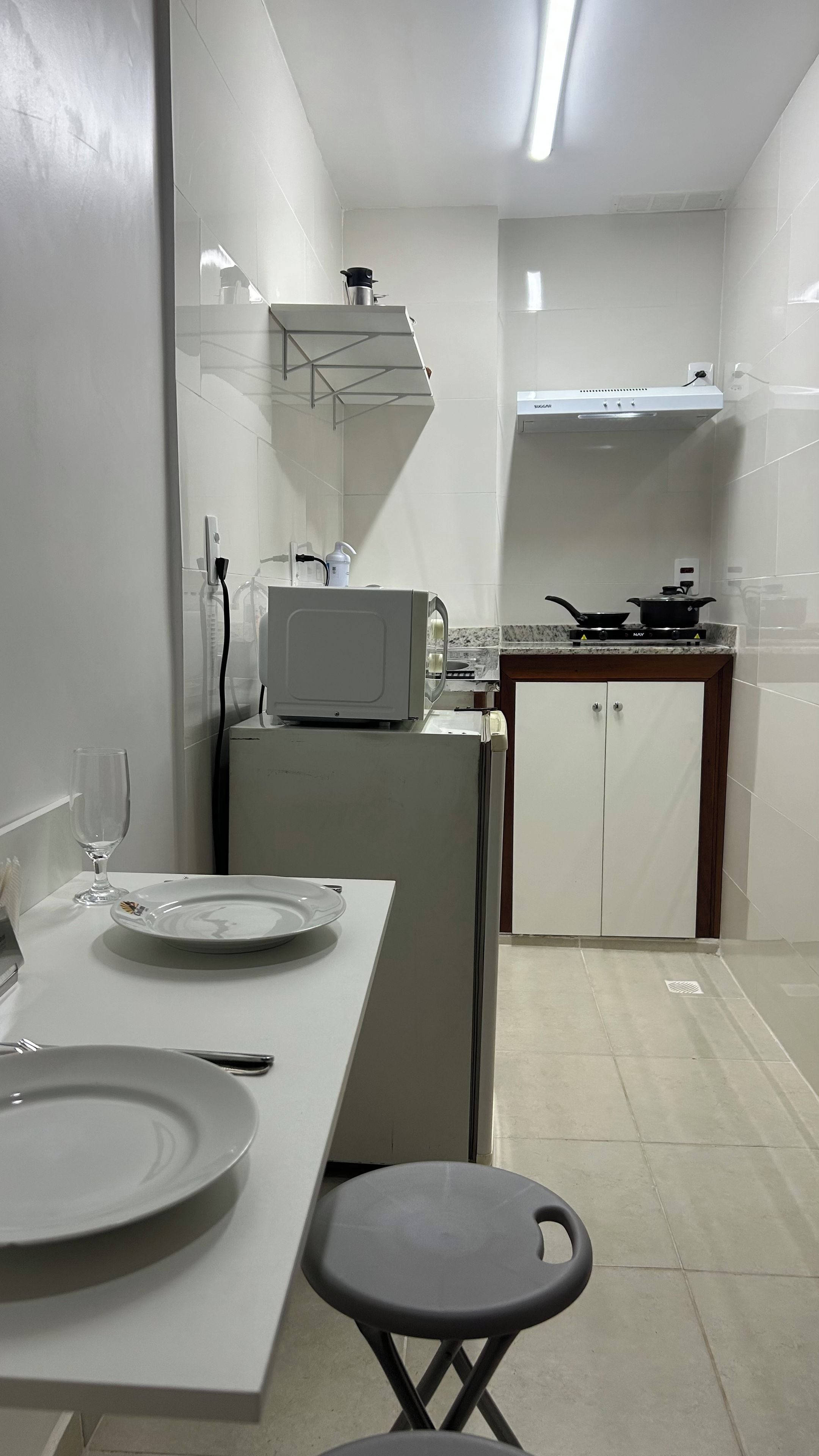 Cocina compacta con microondas, estufa y armarios.