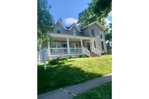Stroll up to the charming entrance of this two-story home, where a welcoming porch and beautifully manicured lawn await.