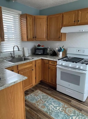 Enjoy cooking in this well-equipped kitchen with a gas stove, microwave, and stainless steel sink.
