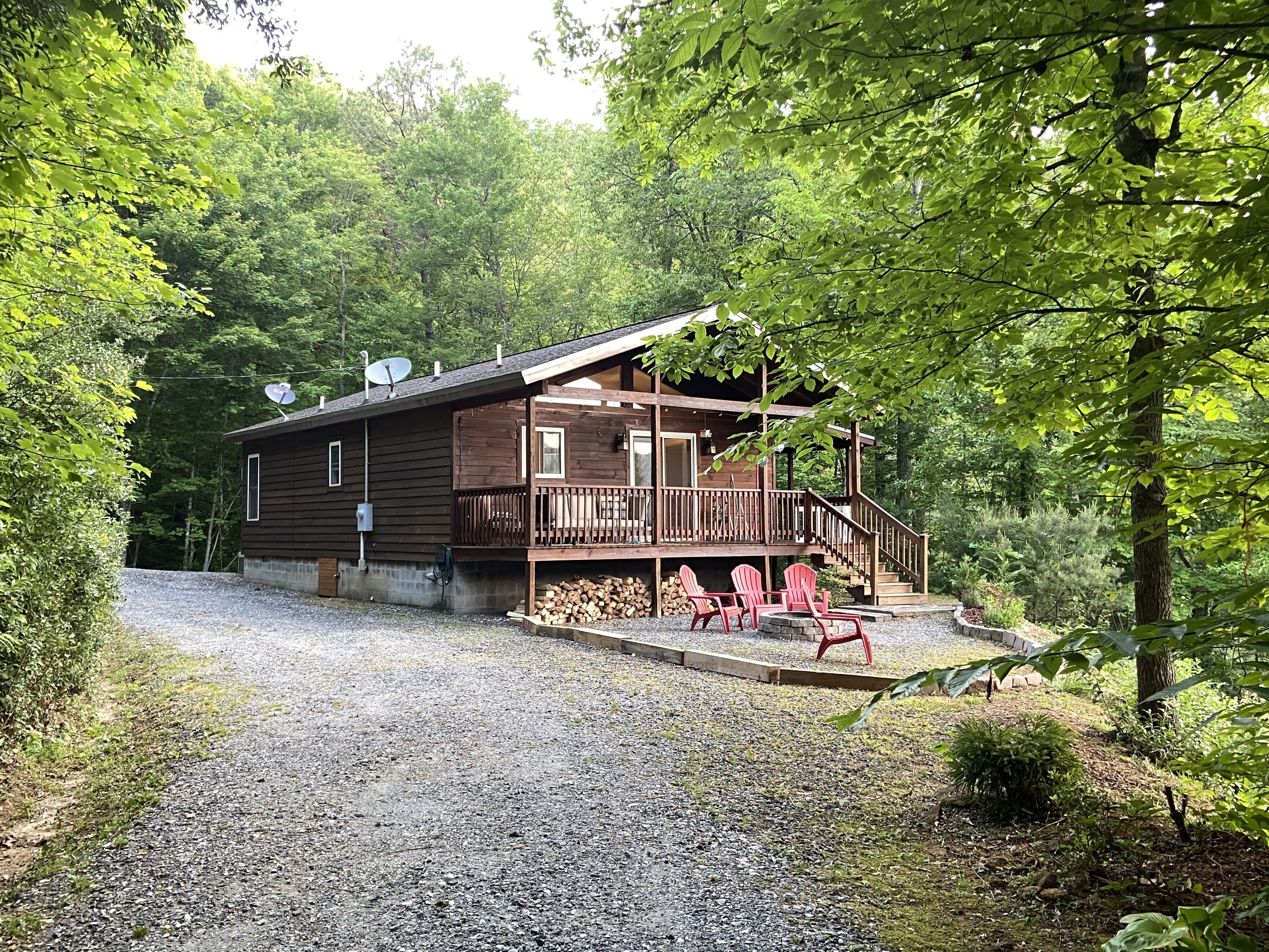 Une cabane dotée d’une terrasse, entourée d’arbres.