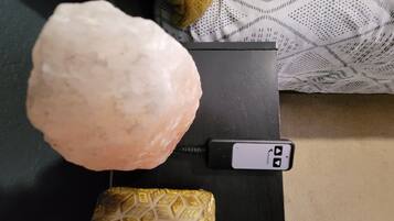 A salt lamp, a decorative item, and a small, patterned object on a black surface.