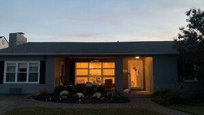 Eenlaags huis met een veranda, een kleine tuin en het cijfer '200' op de deur.
