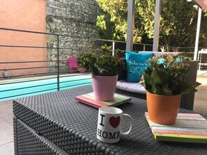 Una piscina al aire libre de temporada, sillones reclinables de piscina