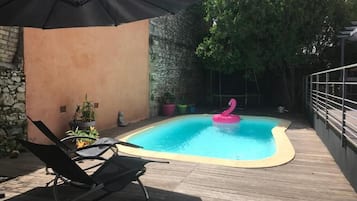 Una piscina al aire libre de temporada, sillones reclinables de piscina