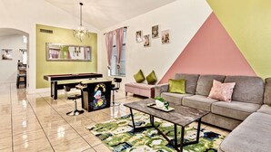 Un salon moderne avec une table de billard, un canapé et une table basse.