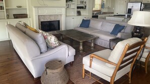 Una sala de estar con sofá, sillón, mesa de centro y chimenea.