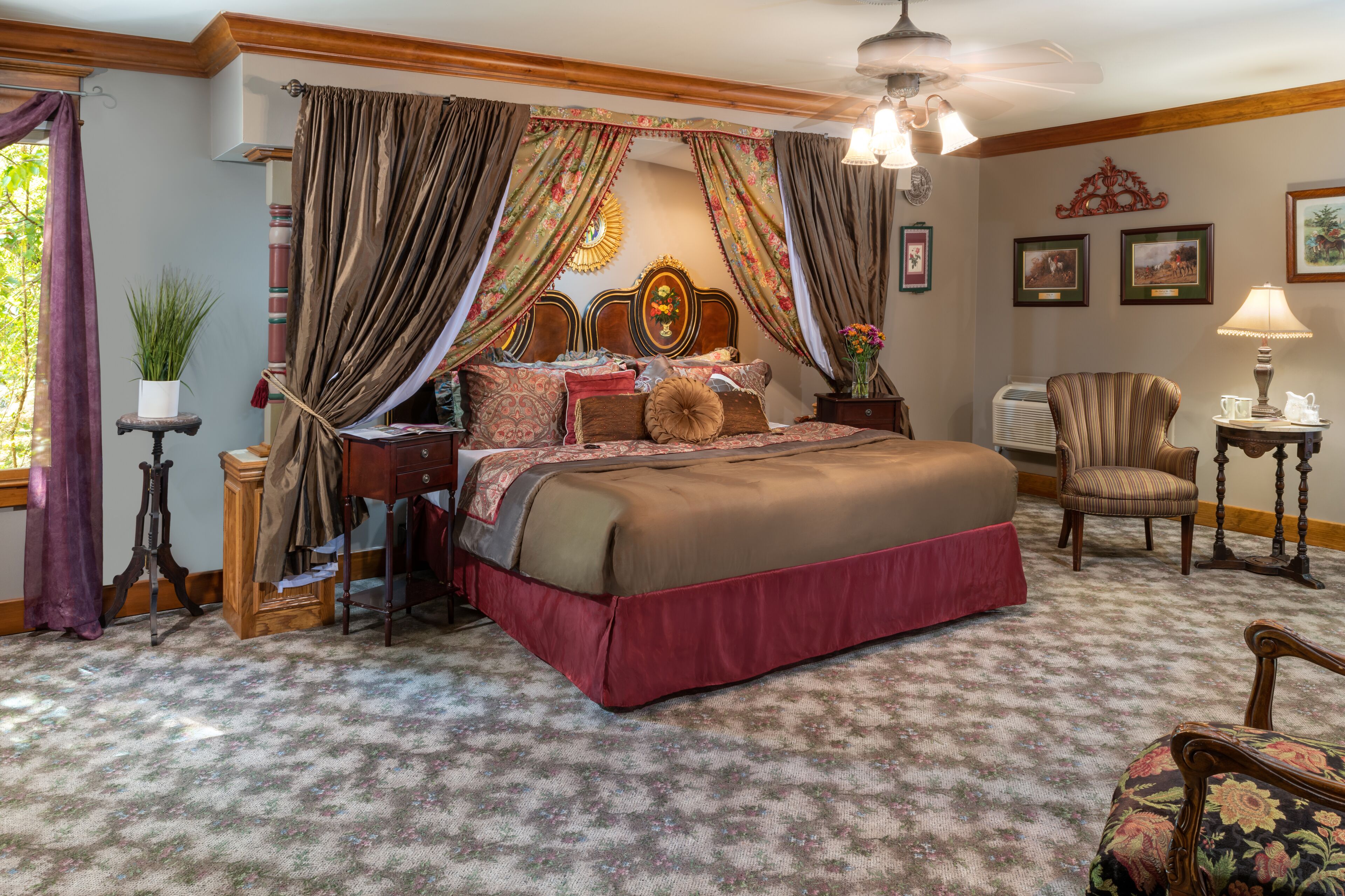 A bedroom with a large bed, a chair, a table, and a lamp.