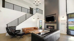 A spacious living area with a staircase, a fireplace, a television, and a large window. - La Bella Vita (The Beautiful Life) 5+ Bedrooms (Spearfish)