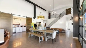 A spacious dining area with a high ceiling and a staircase leading to an upper level. - La Bella Vita (The Beautiful Life) 5+ Bedrooms (Spearfish)